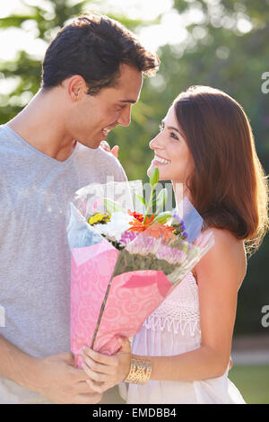 Romantic Man Giving Woman Bunch Of Flowers Stock Photo - Alamy