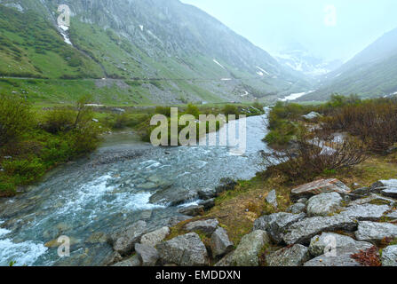 Passo del San Gottardo or St. Gotthard Pass summer misty landscape (Switzerland). Rainy weather Stock Photo