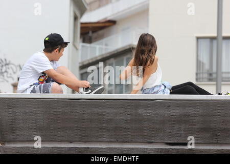 two children sitting on a concrete platform chilling, relaxing Stock Photo