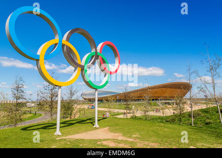 A blue sky image of the  Olympic Rings with the Lee valley Velopark in the background Queen Elizabeth Olympic Park Stratford, London England UK Stock Photo