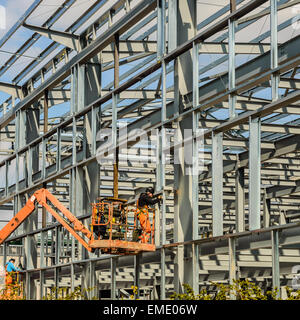 Construction site on Sports Direct property. A construction worker using an angle grinder to cut a metal girder. In Shirebrook. Stock Photo