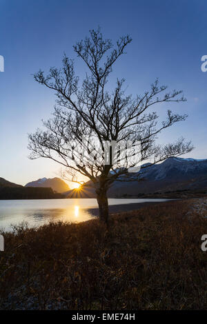 The sun sets behind the slopes of Beinn Eighe with Liathach in the background. Stock Photo