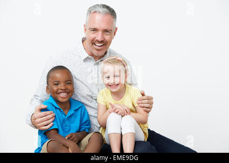 Studio Portrait Of Male Pre School Teacher With Pupils Stock Photo