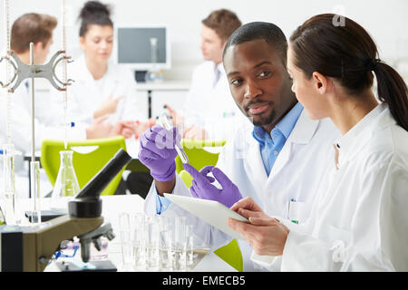 Group Of Technicians Working In Laboratory Stock Photo