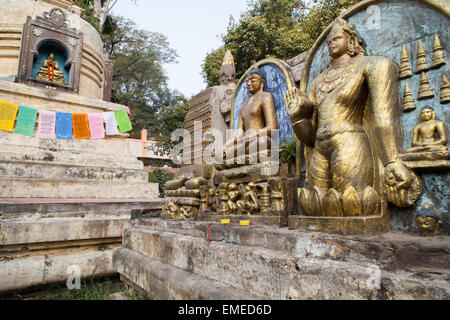 Statues of the Buddha with stupa and prayer flags at the Mahabodhi Temple Complex in Bodhgaya Stock Photo