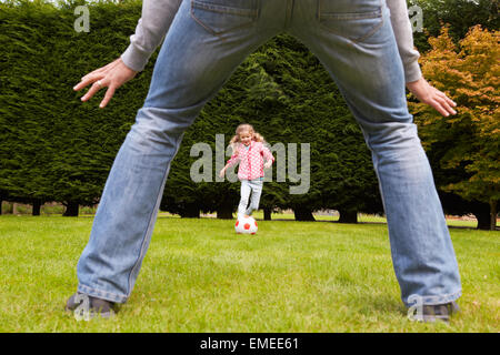 Father And Daughter Playing Football In Garden Together Stock Photo