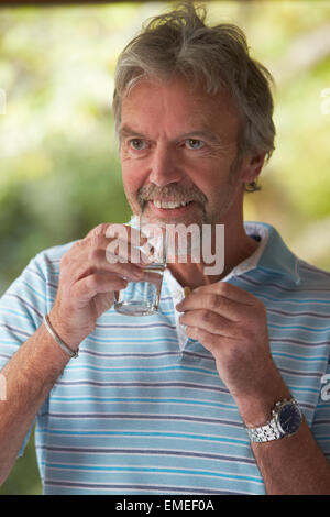 Mature Man At Home Taking Tablet Stock Photo