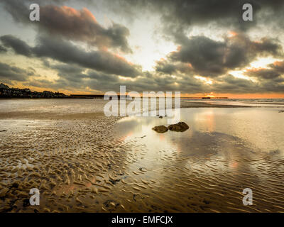 A wonderful sunrise on the beach at low tide with fantastic reflections in the stranded pools Stock Photo