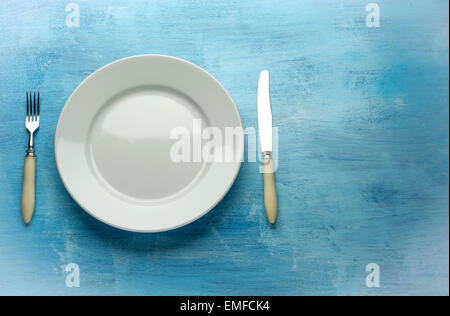 Fork with knife and blank plates. On wooden table Stock Photo