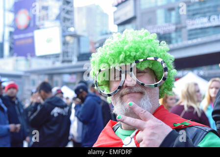 Toronto, Canada. 20th Apr, 2015. Man showing victory sign while green hair and glasses on in Yonge-Dundas Square in Toronto. Credit:  NISARGMEDIA/Alamy Live News Stock Photo