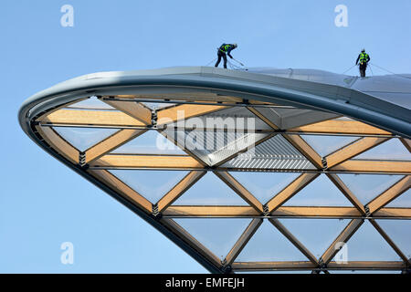 Workmen on new roof of Crossrail Place a retail complex built above the Canary Wharf Crossrail train station London Docklands Tower Hamlets England UK Stock Photo