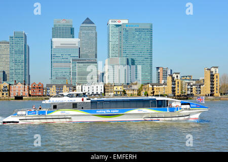 River Thames & London Docklands Canary Wharf skyline of banking HQ modern skyscraper buildings with Thames Clippers fast river bus service passing UK Stock Photo