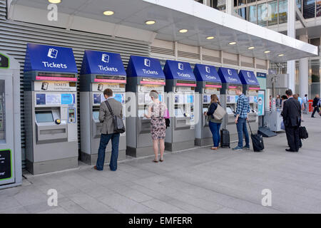 Railway passengers at self service ticket machines for card & cash payment for buying train or Oyster card tickets at London Bridge station England UK Stock Photo