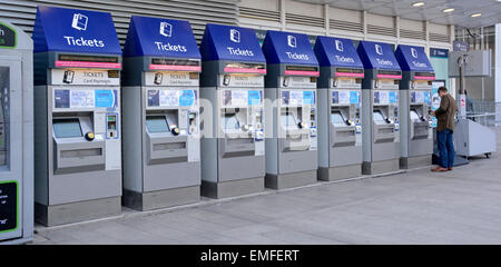 Railway passenger at self service ticket machines for card & cash payment for buying train or Oyster card tickets at London Bridge station England UK Stock Photo