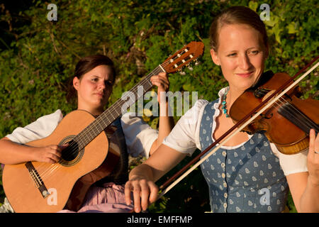 two girls in traditional costumes playing music, Altaussee, Styria, Austria Stock Photo