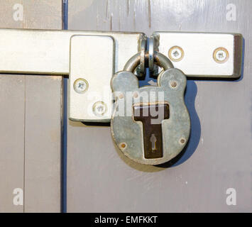 Locked padlock on grungy grey door Stock Photo