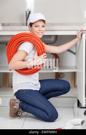 Woman plumber fixing the kitchen Stock Photo