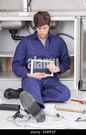 Plumber fixing kitchen Stock Photo