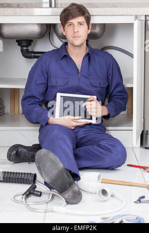 Plumber fixing kitchen Stock Photo