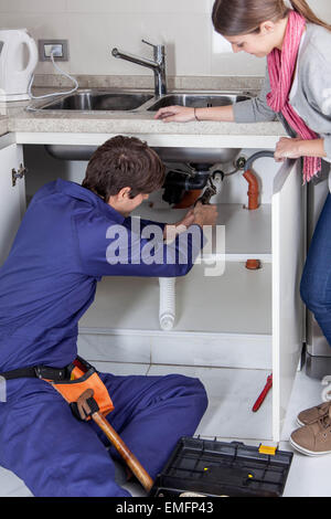 Plumber working on the kitchen Stock Photo