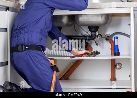 Plumber working on the kitchen Stock Photo