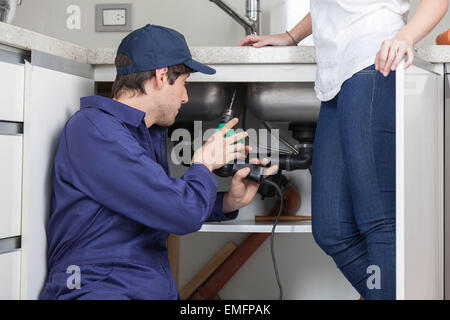 Plumber working on the kitchen Stock Photo