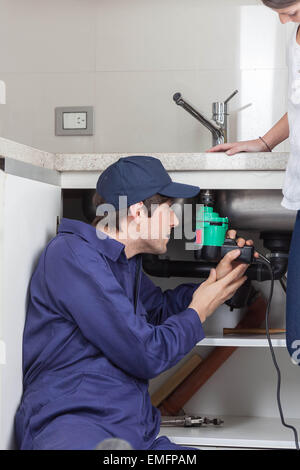 Plumber working on the kitchen Stock Photo