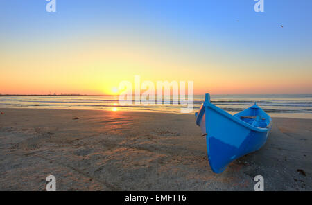 Boat on the beach at sunrise time Stock Photo