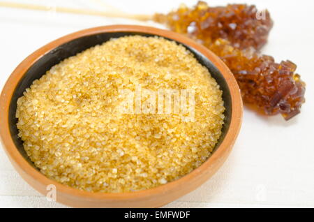 Bowl full with brown sugar and two sugar sticks in the background Stock Photo