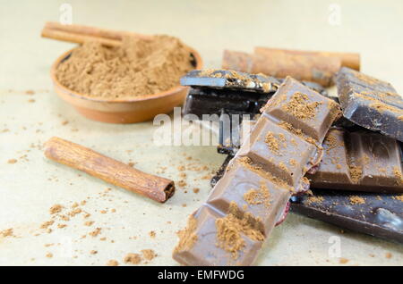 Bunch of chocolate sticks, cinnamon and hazelnuts on a table Stock Photo