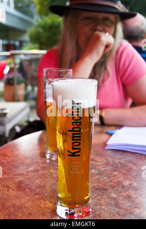 A printed glass of Krombacher Pils lager beer, Wuppertal, Nordrhein-Westfalen, Germany, pub table drinks glasses Stock Photo