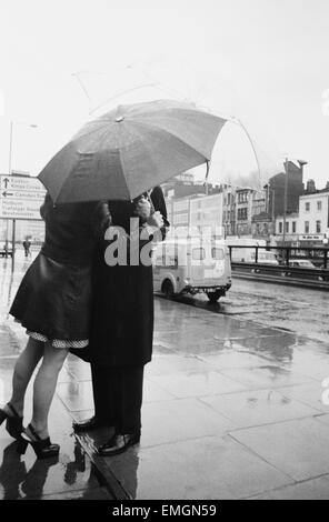 Dr Michael Ramsey, the Archbishop of Canterbury is given a birthday kiss by Bank clerk Susan Hayes as he arrives at Thames Television studios to view a special documentary to mark his retirement. Susan, who works in a nearby bank, was returning from lunch when she saw the Archbishop arrive and rushed up to him to wish him many Happy Returns. 11th November 1974. Stock Photo