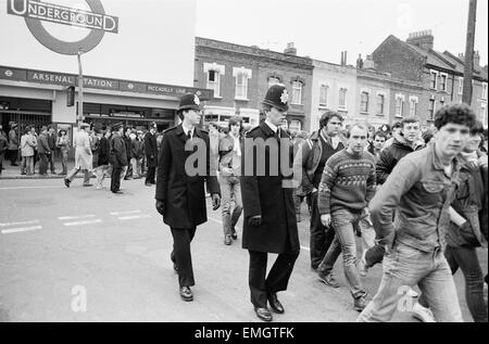 Police keep an eye on Leeds United supporters at the Arsenal football ground as fans arrive at Arsenal station ahead of the match. 29th January 1983. Stock Photo