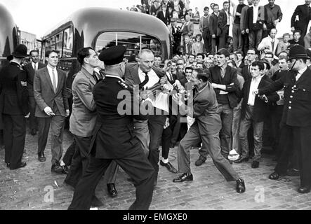 Large crowd gathered in Ridley Road E8 to demonstrate against former fascist leader Sir Oswald Mosley and members of his anti-Semitic Blackshirt group who had planned a rally in London's East End. Mosley and his anti-Semitic Blackshirt were assaulted and punched to the ground as soon as his meeting opened at Ridley Road, Dalston. Police closed the meeting within the first three minutes and made 54 arrests one of the arrested was Sir Oswald's son Max. 2nd August 1962 Our Picture Shows: Sir Oswald Mosley being knocked to the ground Stock Photo