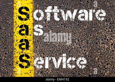 Business Acronym SaaS as SOFTWARE AS A SERVICE. Yellow paint line on the road against asphalt background. Conceptual image Stock Photo
