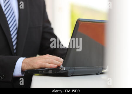 Business man hand working using a laptop in the street isolated in white on the right side Stock Photo