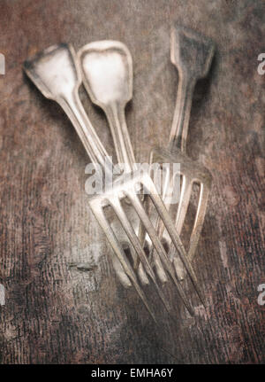 Still life with three forks lying on wooden table, close up. Stock Photo