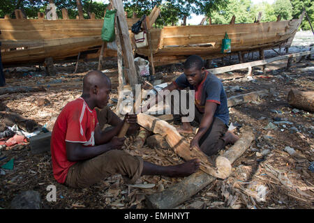 Craftsmen building a traditional wooden dhow cargo ship in 