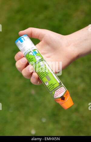 A boy using an Epipen in his thigh demonstrating what to do in the event of an anaphylactic shock Stock Photo