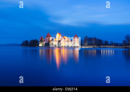 Island castle on Galve lake illuminated at dusk in Autumn. Trakai, Lithuania Stock Photo