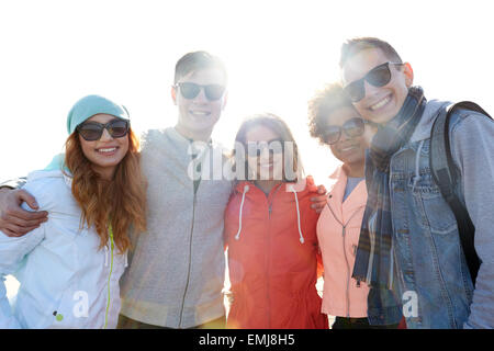 happy teenage friends in shades hugging on street Stock Photo