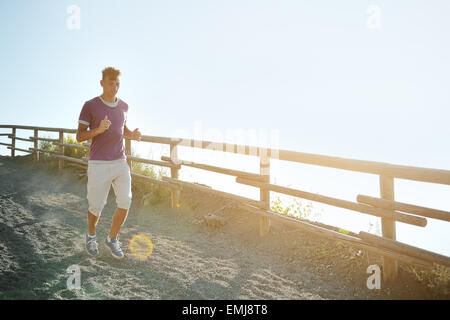 young man runs on a mountain trail Stock Photo