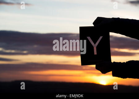 Hands holding letter Y at sunrise. Silhouette Stock Photo