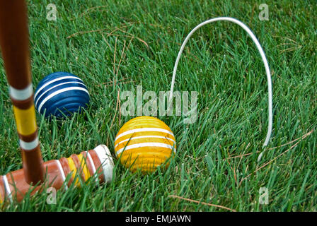 Croquet mallet and wooden croquet ball in grass with wicket. Stock Photo