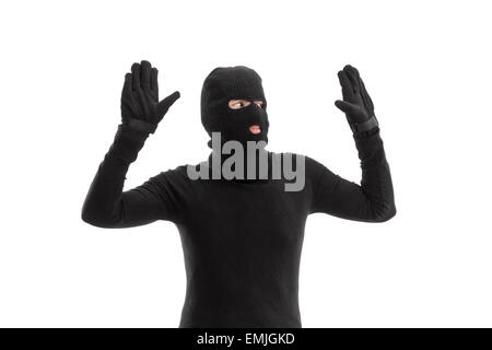 Thief in black costume surrendering to someone isolated on white background Stock Photo