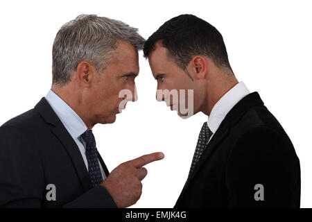 Younger and older businessmen head to head Stock Photo