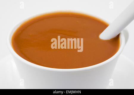 Close view of a cup of tomato soup with a spoon. Stock Photo