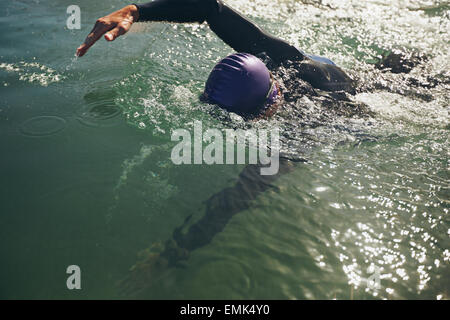 Male swimmer swimming in open water. Athlete practicing for the competition. Stock Photo
