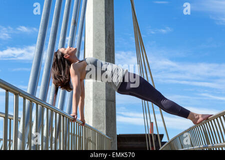 Reverse plank yoga pose performed on a bridge, San Diego, California Stock Photo