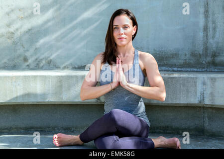 Cow Face Yoga posture variation performed outdoors on a bench, San Diego, California Stock Photo